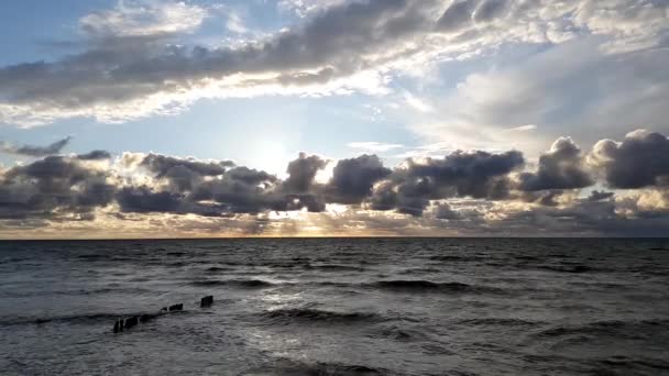 Puesta de sol en el mar Báltico, cielo nublado, olas pequeñas — Vídeos de Stock