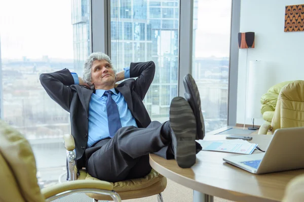 Mature businessman relaxing in the office — Stock Photo, Image