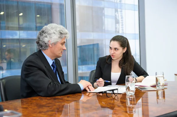 Rijpe zakenman en jonge zakenvrouw bespreken — Stockfoto