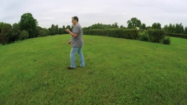 Man lopen in het park met smartphone — Stockvideo