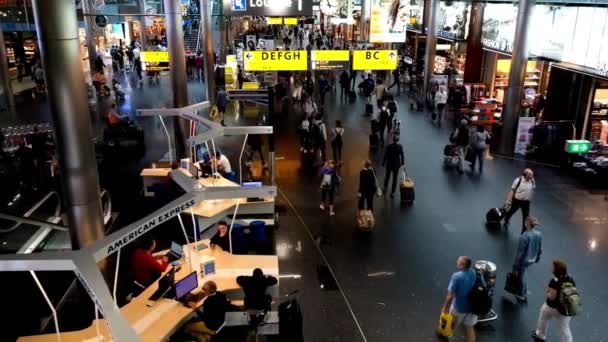 Människor besöker avgångshallen i internationella flygplatsen Schiphol — Stockvideo