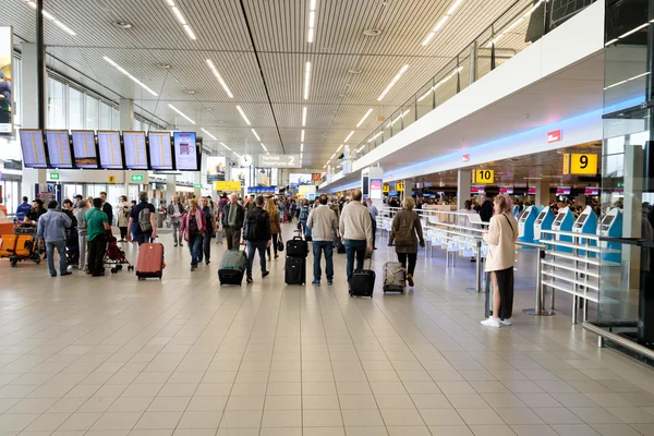 La gente visita la sala partenze nell'aeroporto internazionale di Schiphol — Foto Stock