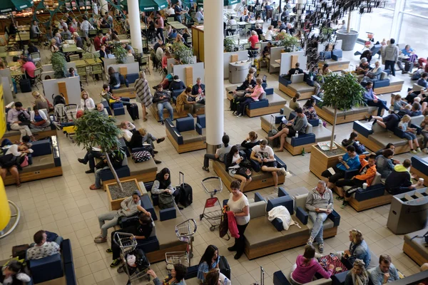 Lidé navštěvují odletové hale v mezinárodním letišti Schiphol — Stock fotografie