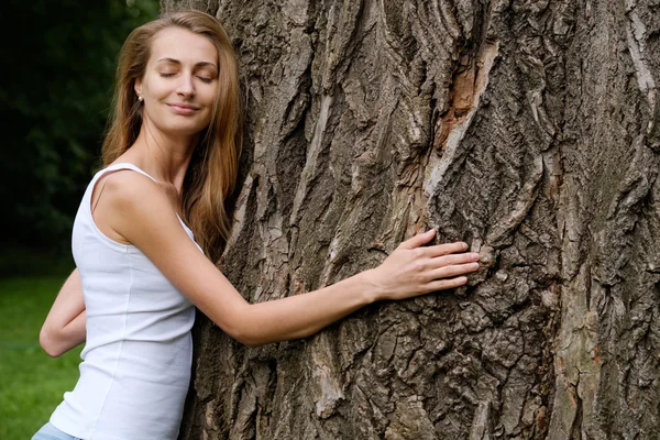 Giovane donna abbracciare grande albero — Foto Stock