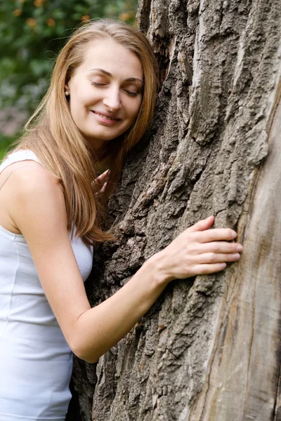 Junge Frau umarmt großen Baum — Stockfoto