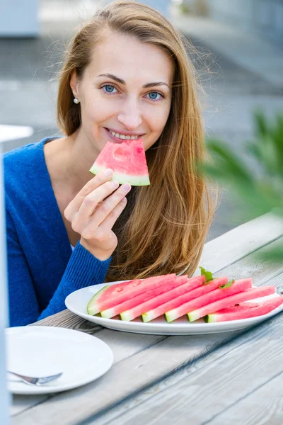 Mujer joven comiendo sandía — Foto de Stock