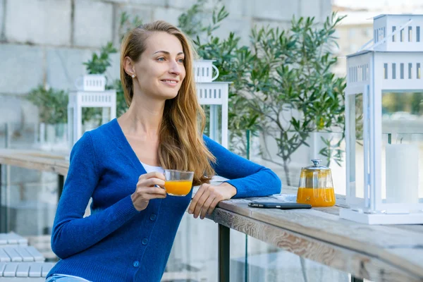 Nuori kaunis nainen nauttii kupin teetä — kuvapankkivalokuva
