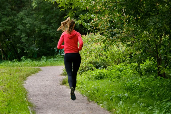 Ung kvinna jogga i parken — Stockfoto