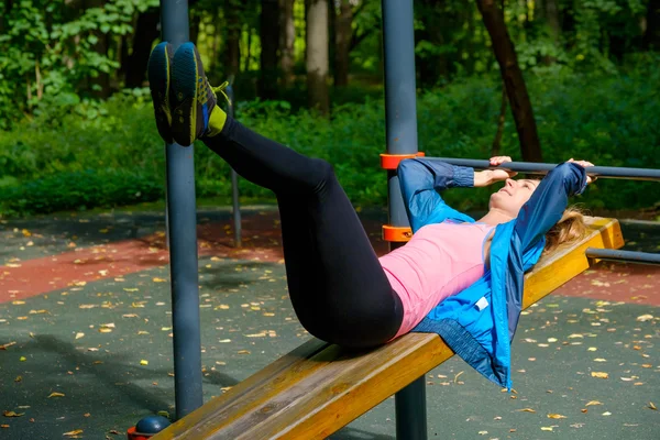 Jovem magro mulher fazendo treino em campo de treinamento — Fotografia de Stock