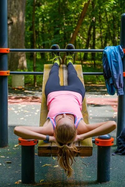 Jovem magro mulher fazendo treino em campo de treinamento — Fotografia de Stock