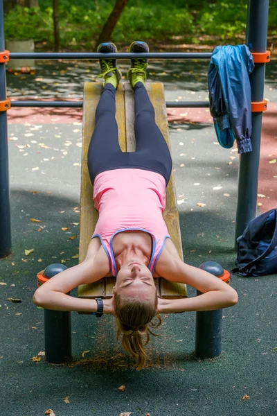 Jovem magro mulher fazendo treino em campo de treinamento — Fotografia de Stock