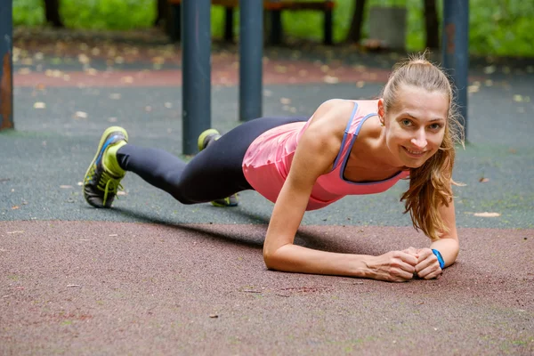 Young slim woman doing workout in a training ground — Stock Photo, Image