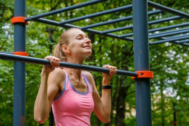 Genç ince kadın üzerinde yatay çubuk çeker
