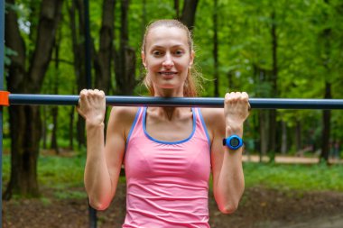 Genç ince kadın üzerinde yatay çubuk çeker