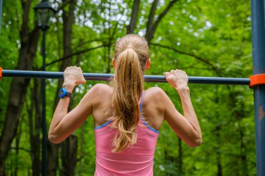 Genç ince kadın üzerinde yatay çubuk çeker