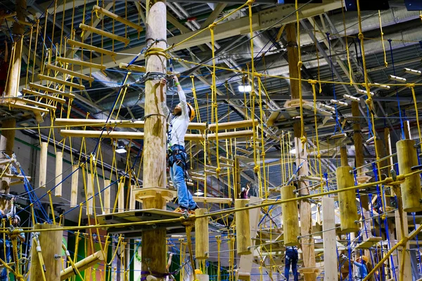 Crianças de 6 a 12 anos frequentam o parque de escalada de aventura indoor — Fotografia de Stock