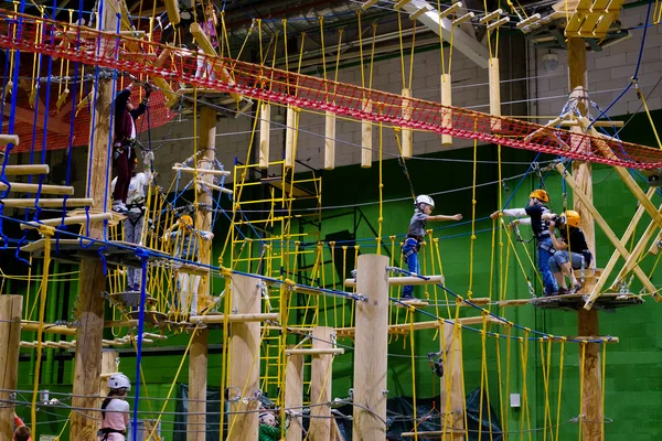 Crianças de 6 a 12 anos frequentam o parque de escalada de aventura indoor — Fotografia de Stock