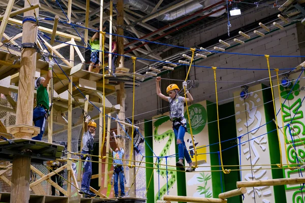 Děti 6-12 let navštěvovat krytý dobrodružství lezení park — Stock fotografie