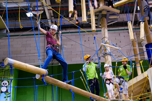Crianças de 6 a 12 anos frequentam o parque de escalada de aventura indoor — Fotografia de Stock