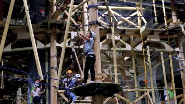 Children age 6-12 attend indoor adventure climbing park — Stock Video