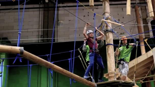 Crianças de 6 a 12 anos frequentam o parque de escalada de aventura indoor — Vídeo de Stock