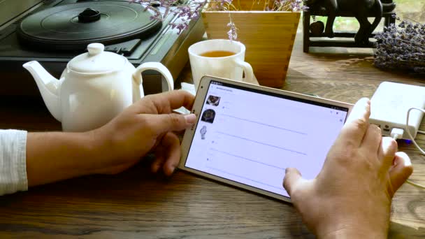 Hombre visita aliexpress sitio web utilizando tableta PC en la cafetería — Vídeo de stock