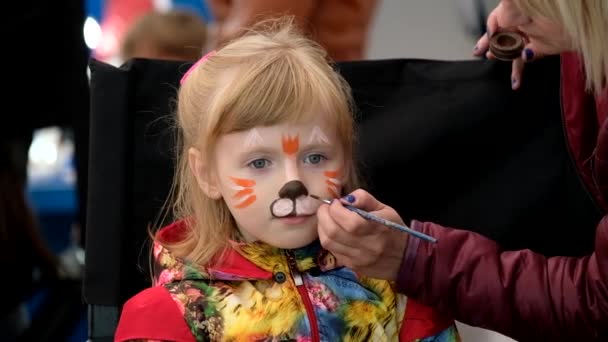 Kunstenaar geldt grappige kat make-up voor meisje leeftijd 7 jaar — Stockvideo