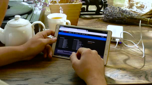 Hombre visita sitio de la empresa momondo utilizando tableta PC en la cafetería — Vídeos de Stock