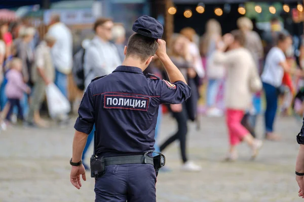 Tanınmayan bir polis memuru kalabalığa doğru yürüyor.