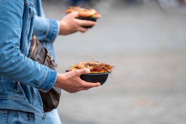 Sokakta deniz mahsulleri taşıyan insanlar.