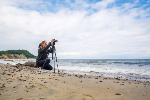 Vrouwelijke fotograaf schieten zwaaien zee — Stockfoto