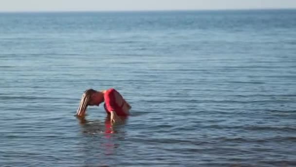 Mujer joven divirtiéndose en el agua de mar — Vídeos de Stock