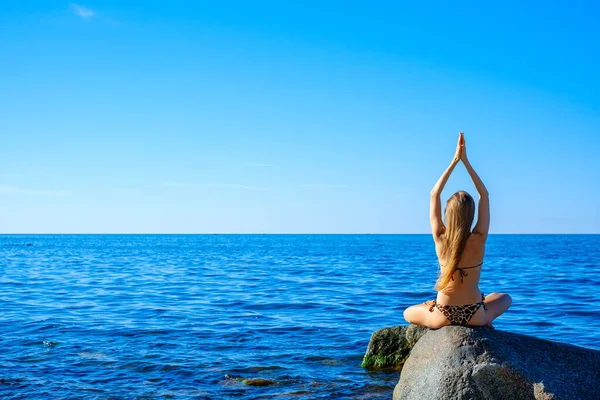 Mujer meditando por la mañana cerca del mar — Foto de Stock