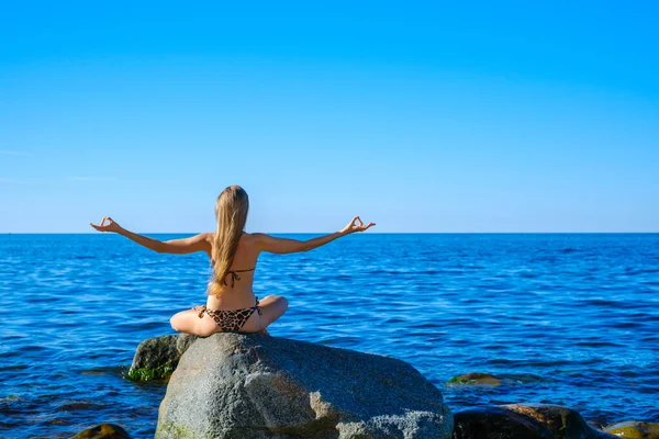 Mulher meditando de manhã perto do mar — Fotografia de Stock