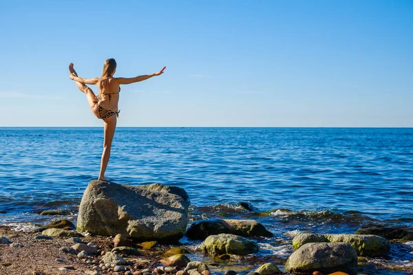 Mujer de pie en la mano a los pies posan cerca del mar — Foto de Stock