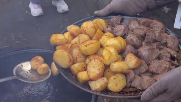 Pessoas que servem batatas fritas com carne — Vídeo de Stock