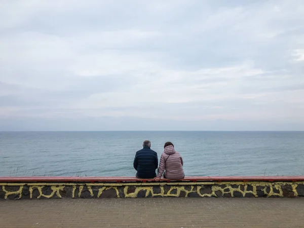 Couple d'âge mûr méconnaissable reposant sur un remblai de mer — Photo