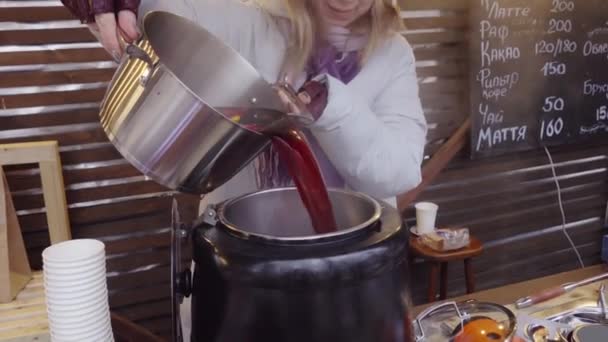 Женщина готовит глинтвейн на рынке — стоковое видео