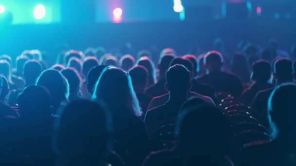 Silhuetas de audiência em feixes de luz de palco — Vídeo de Stock