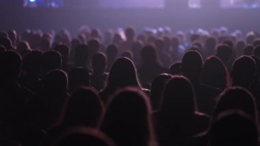 Dinleyiciler konferans salonundaki konuşmacının konuşmasını dinliyor.