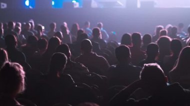Dinleyiciler konferans salonundaki konuşmacının konuşmasını dinliyor.
