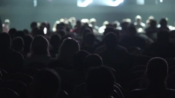 Silhuetas de audiência em feixes de luz de palco — Vídeo de Stock