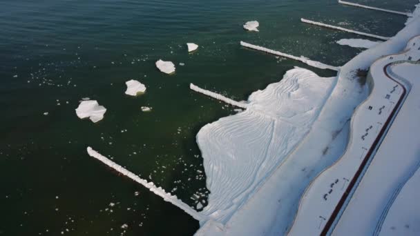 Costiera innevata congelata con ghiaccio galleggiante sull'acqua di mare — Video Stock