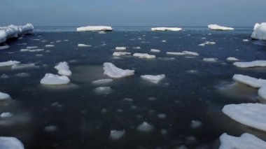 Dalgalı deniz suyunda yüzen çatlak buz