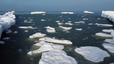 Dalgalı deniz suyunda yüzen çatlak buz