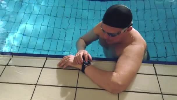 Männlicher Schwimmer misst Puls im Becken — Stockvideo