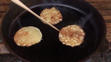 Tanınmayan kişi tavada krep pişiriyor.