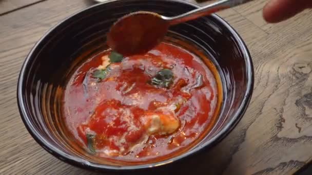 Неузнаваемый человек смешивает красный суп со сметаной — стоковое видео