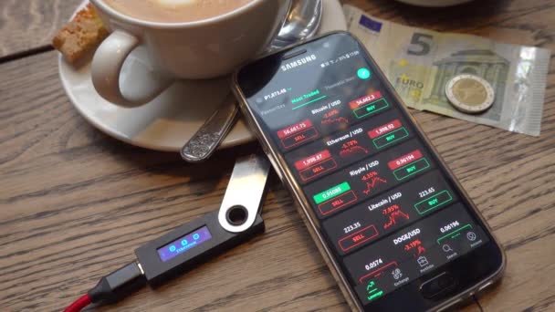 Smartphone with stock market app near coffee and money — Stock Video