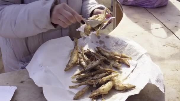 Crop woman putting fried fish on plate — Stock Video